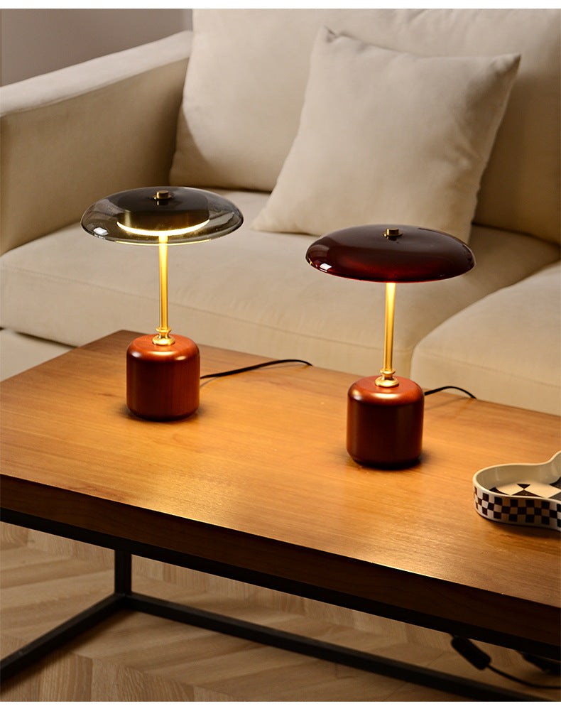Two vintage-style American table lamps on a wooden surface with a neutral background