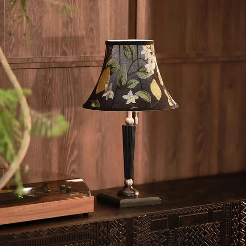Natural daylight on lemon-embroidered silk shade table lamp on an antique wooden shelf