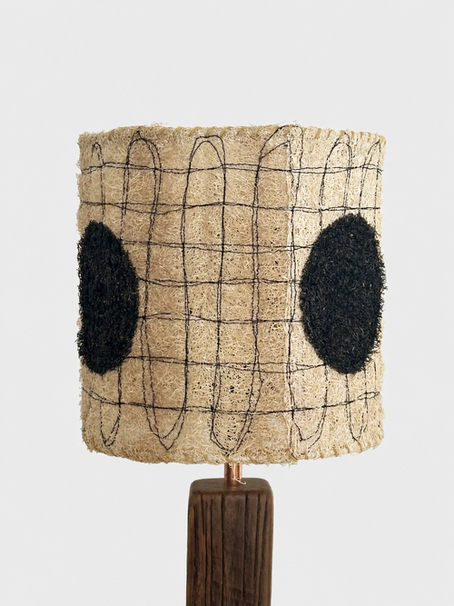 Close-up of the Dottie loofah lampshade with black oval accents and dark stitched linework