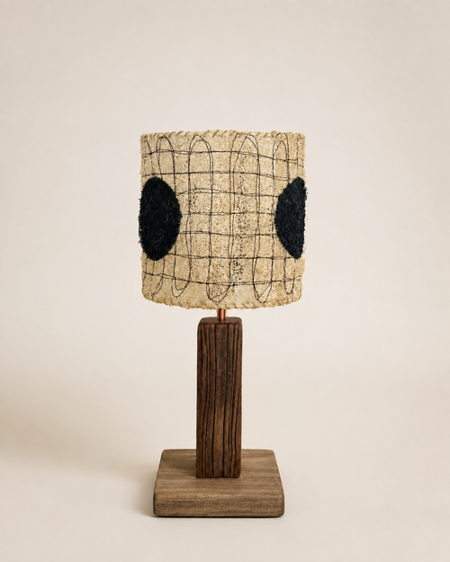 Dottie black dot loofah table lamp with a dark wood stem and square base on a warm beige background