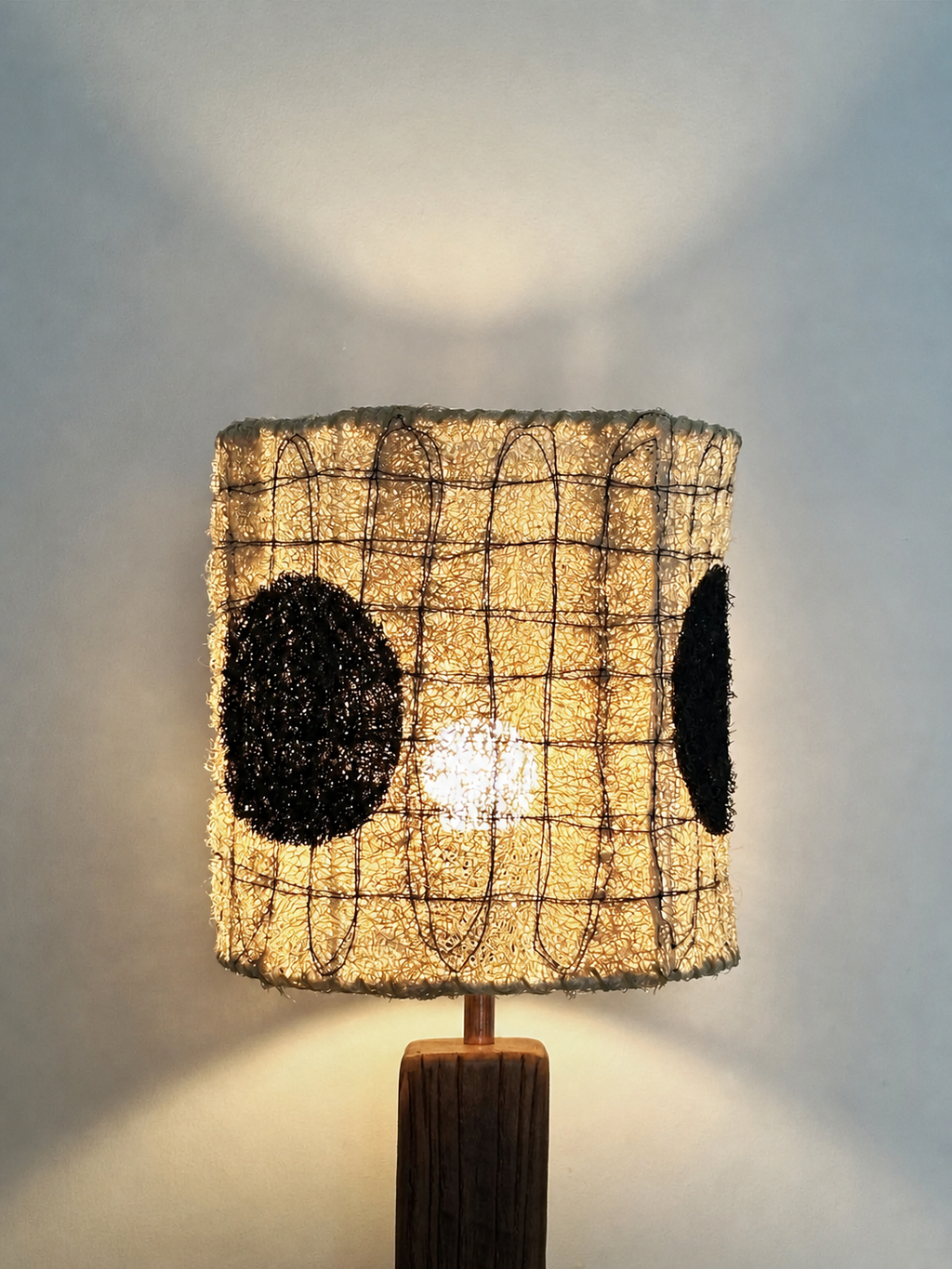 Illuminated close-up of the Dottie loofah lampshade showing warm light through the natural fiber texture