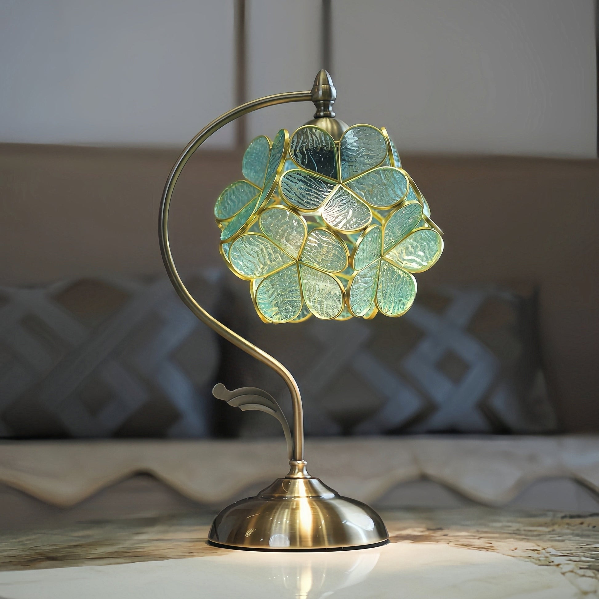 Decorative french vintage table lamp with a floral glass shade on a marble surface.