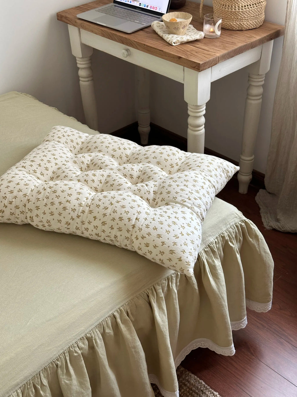 Mustard Floral French vintage patterned pillow cushion styled at the edge of a bed beside a small table.