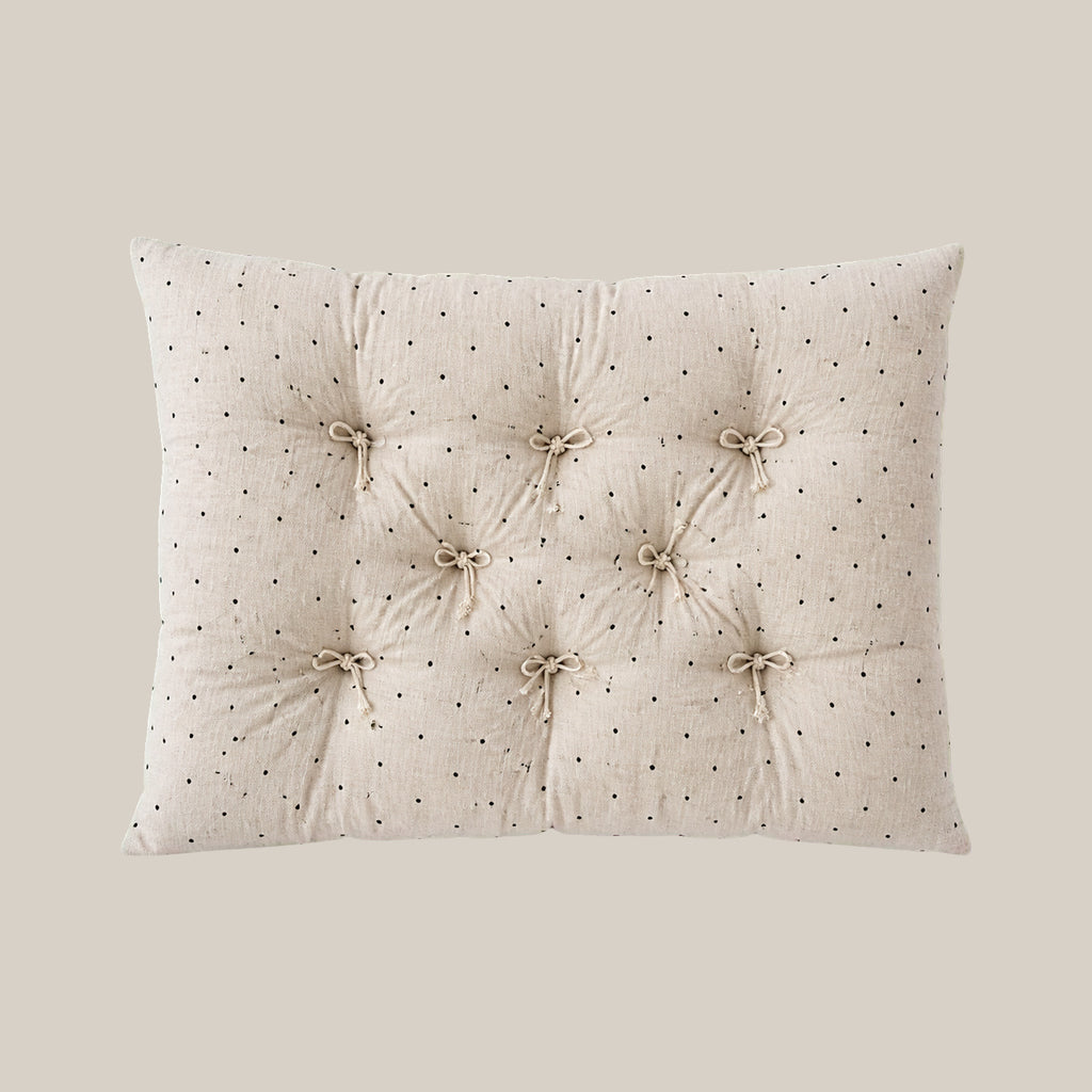 French vintage patterned pillow cushion in Polka Dot style on a warm beige studio background.