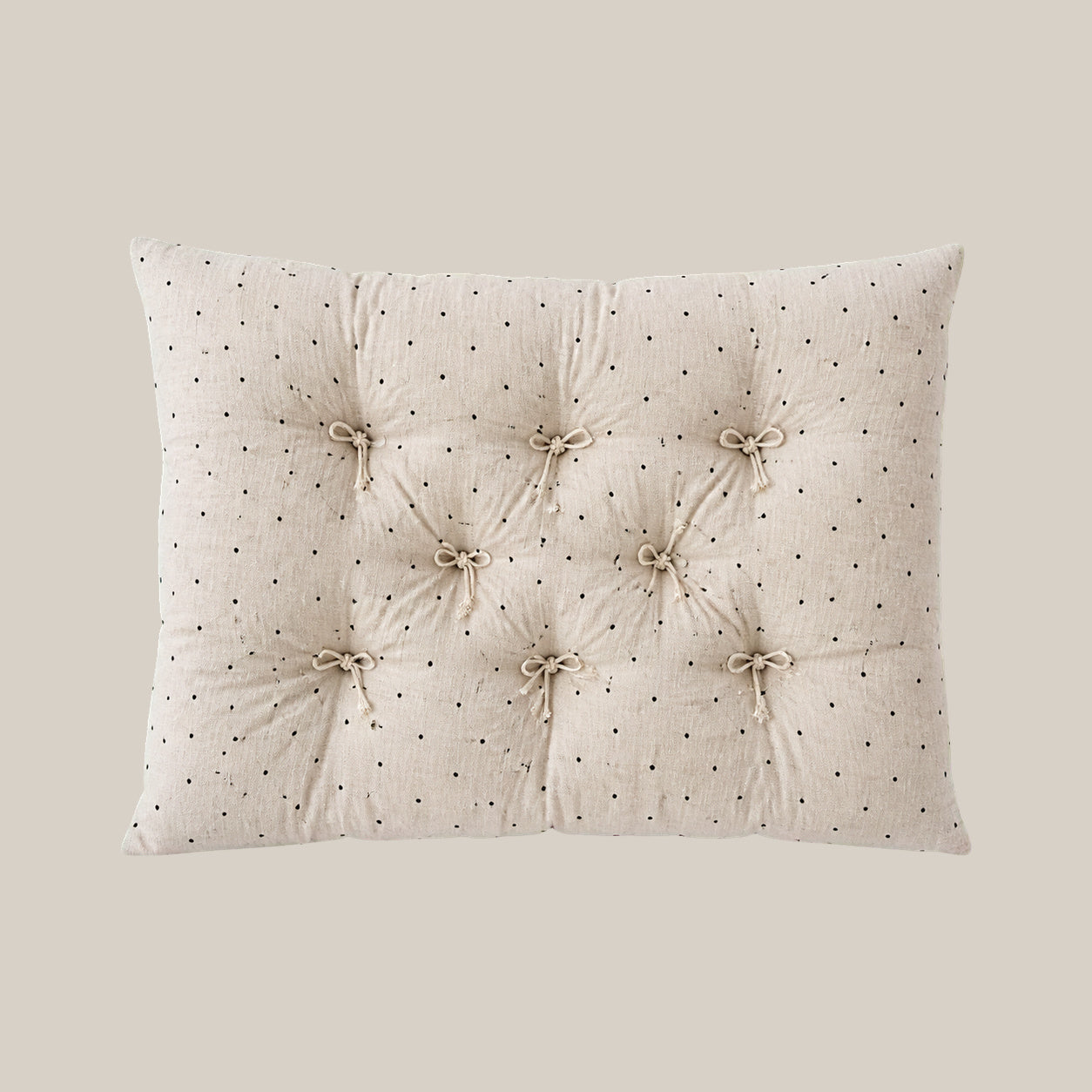 French vintage patterned pillow cushion in Polka Dot style on a warm beige studio background.