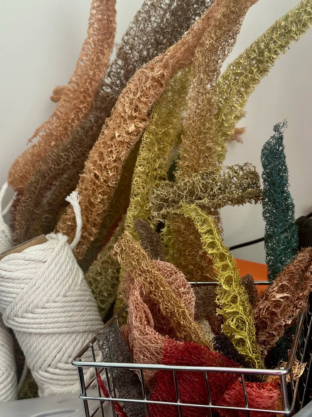 Assorted dyed loofah fiber strips and cotton cord used for handmade loofah lamp making