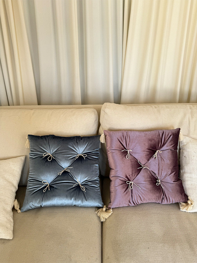 Celestial and Purple Velvet Léonie tufted tassel throw pillows styled on a neutral sofa.