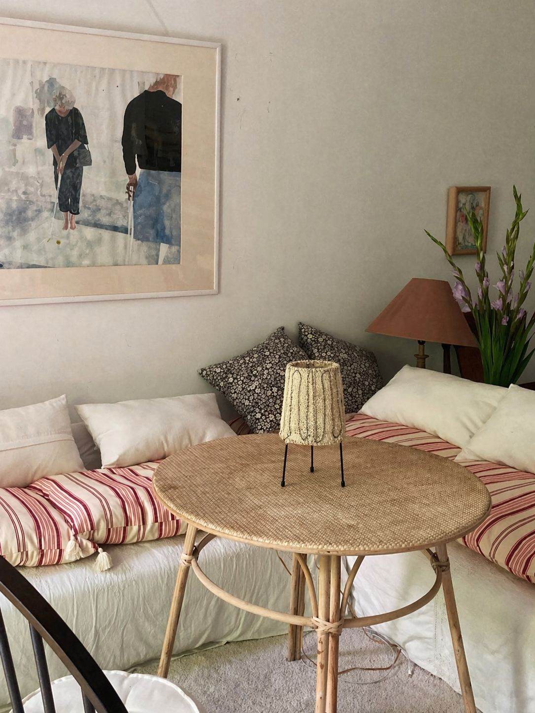 Loop loofah table lamp styled on a rattan table in a cozy neutral lounge corner with striped cushions and layered home decor.