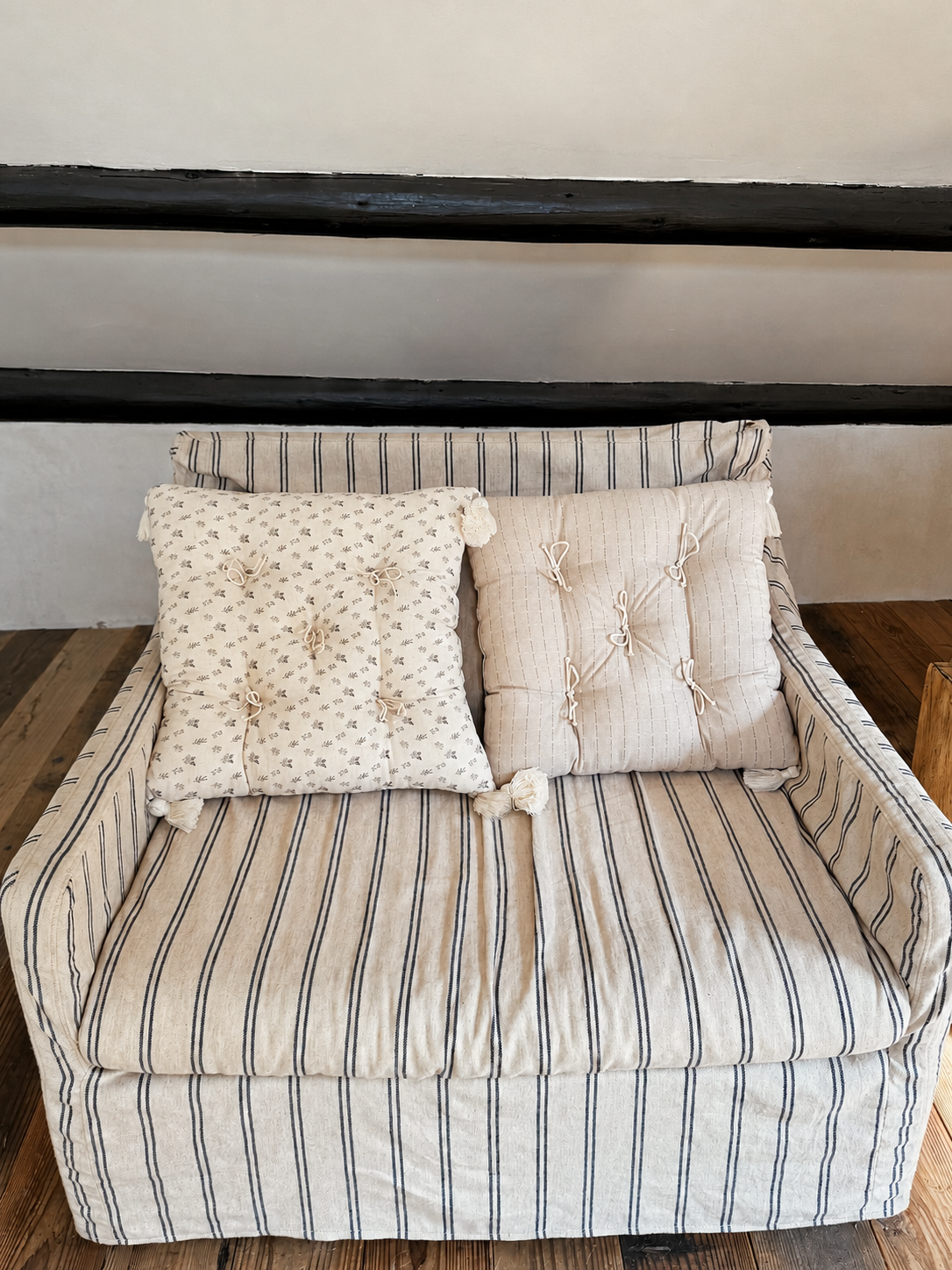 Neutral patterned Mariette tufted tassel throw pillows styled on a striped lounge chair.