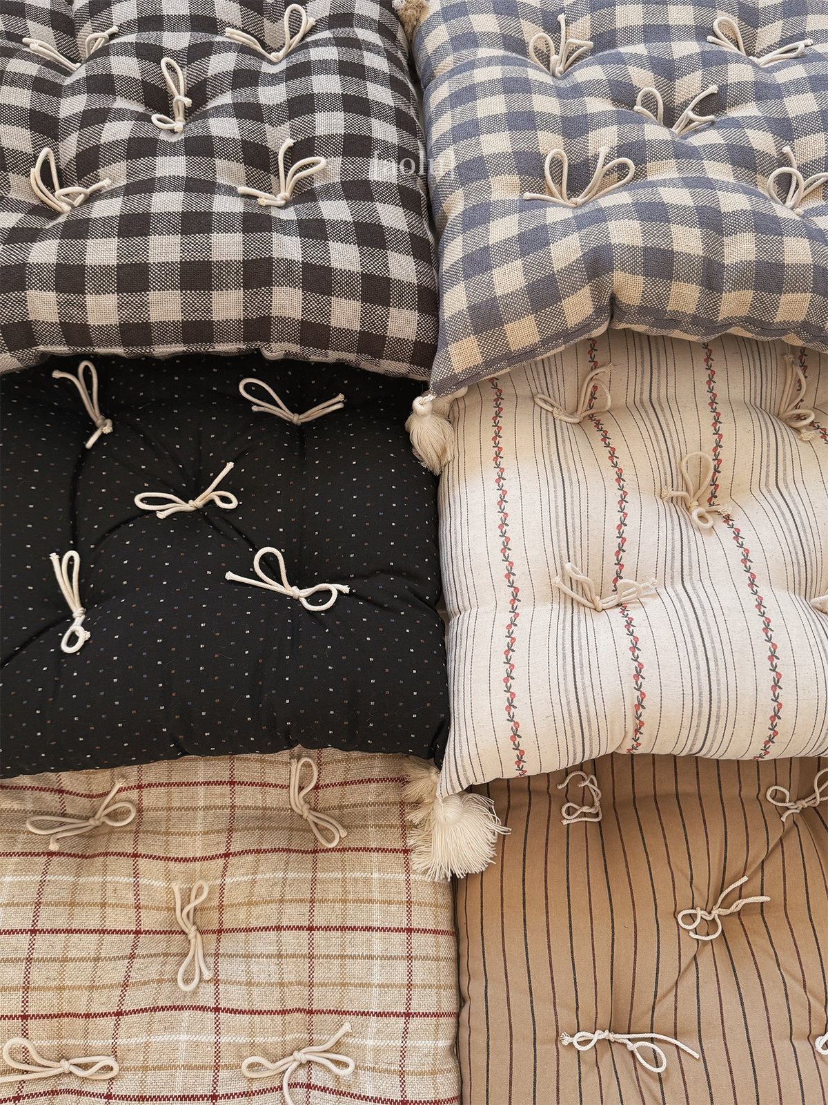 Assorted patterned Mariette tufted tassel throw pillows in a close product overview.