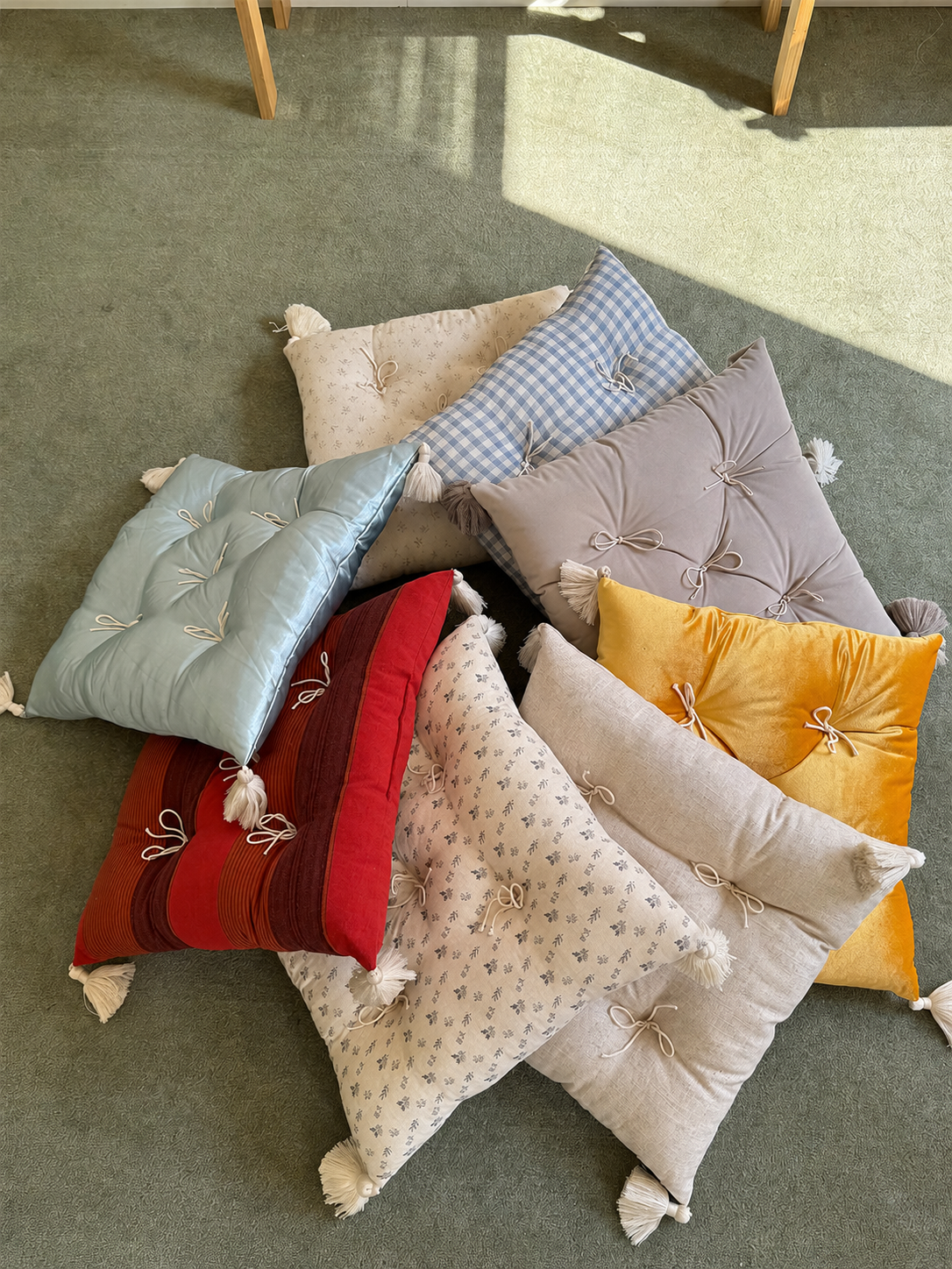 Mixed Mariette tufted tassel throw pillows arranged as a floor collection.
