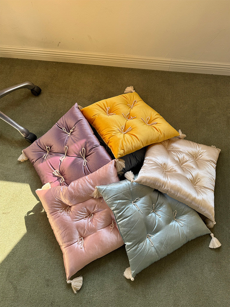 Assorted Mariette velvet tufted tassel throw pillows arranged in a colorful floor display.