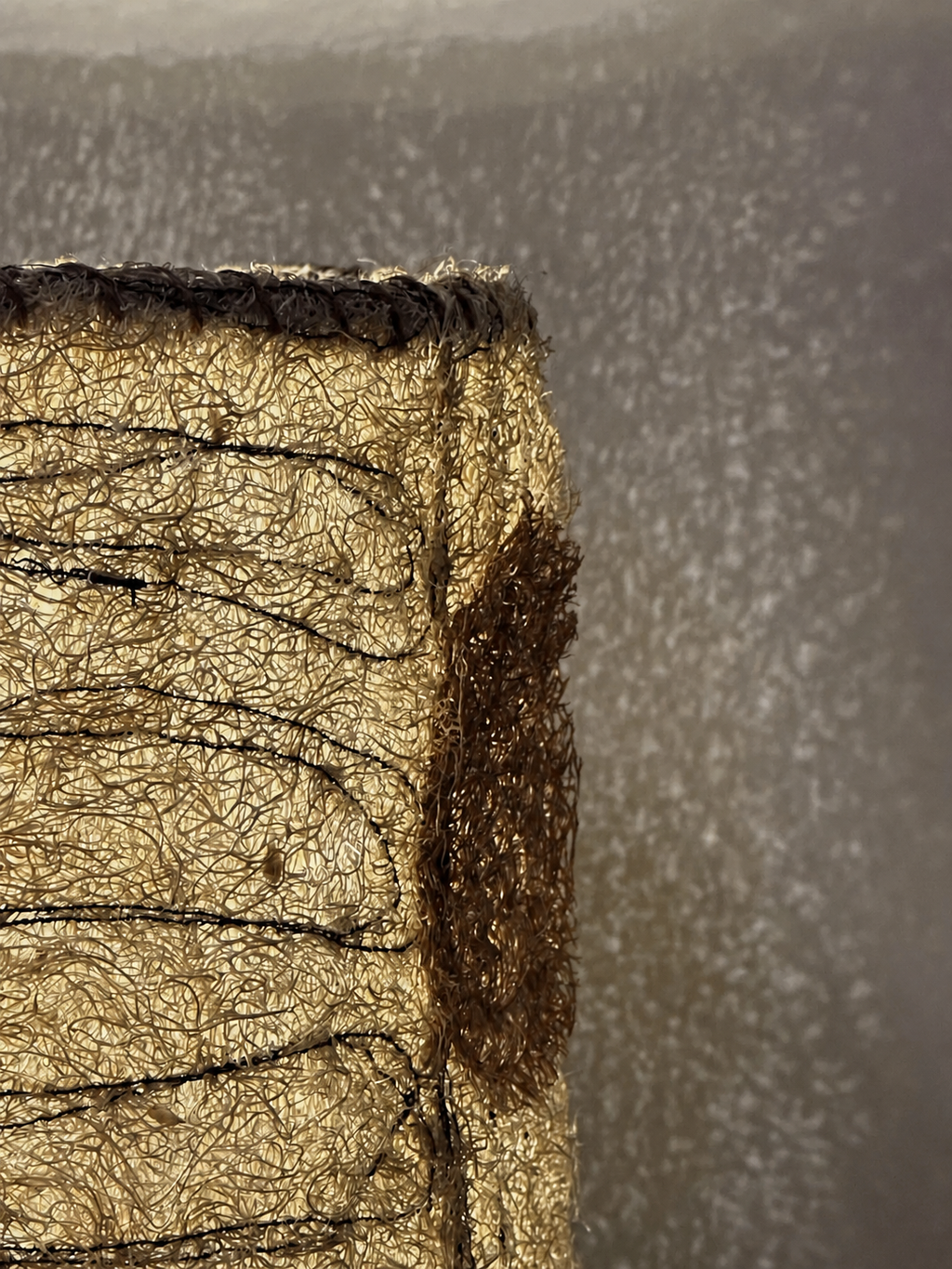 Illuminated close-up of the Petal loofah lampshade showing its textured light pattern