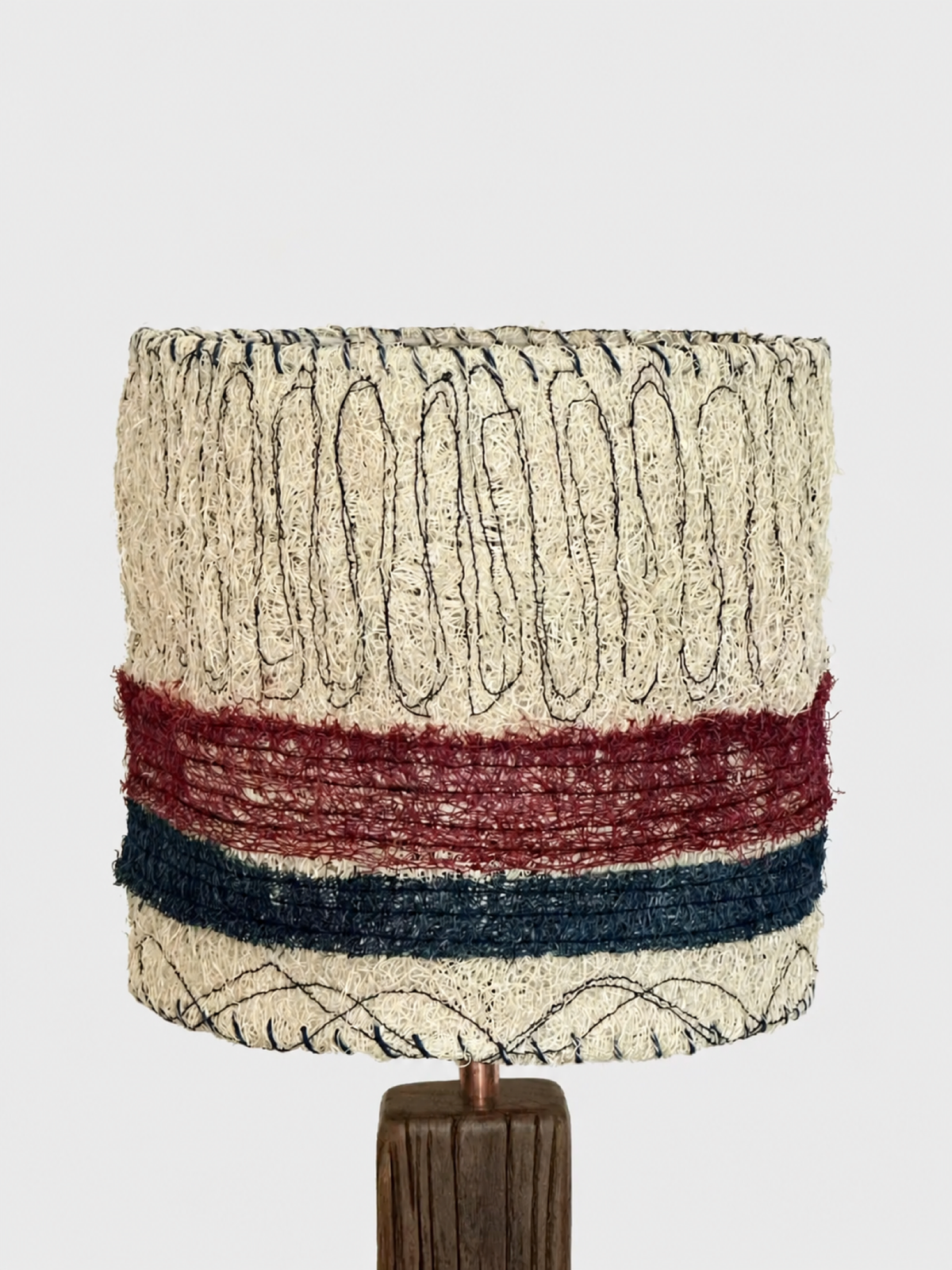 Front detail of the cream loofah lampshade with red and navy horizontal bands