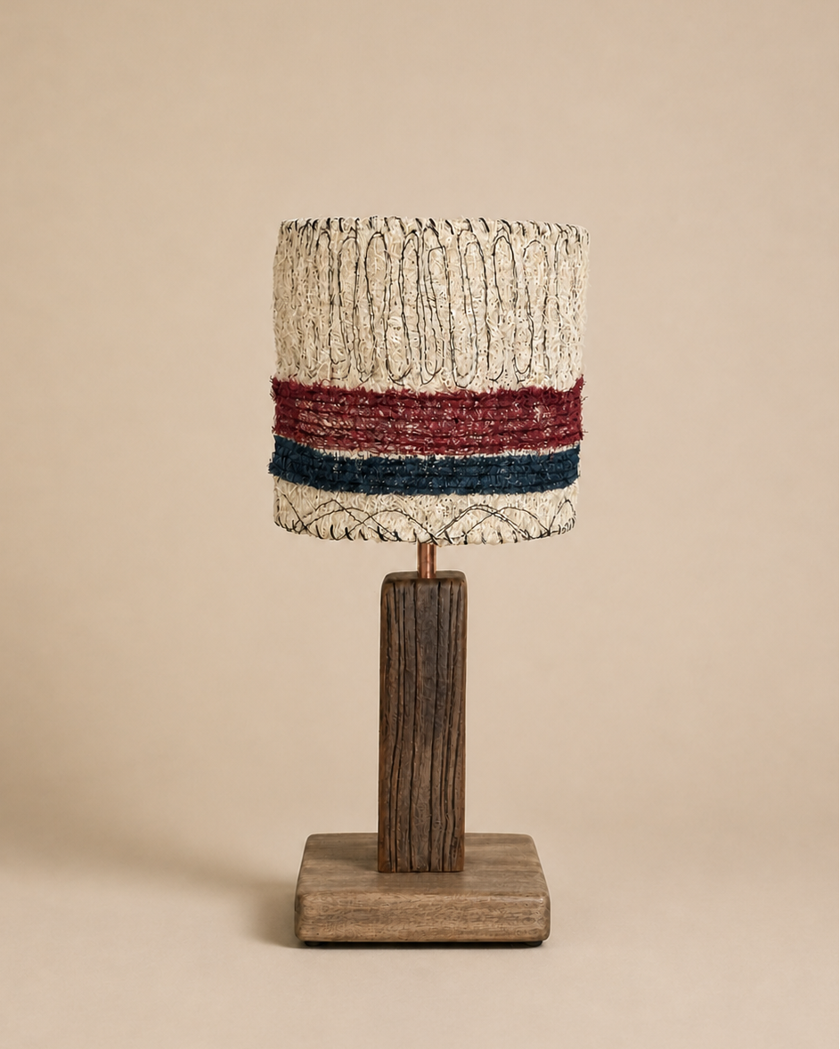 Red and blue striped loofah table lamp with a rectangular wood base on a warm beige background