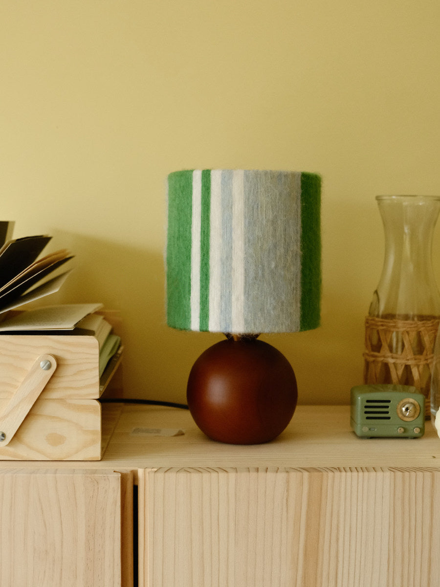 Sage & Forest Mohair & Oak Wood Table Lamp - Verdino displayed on a wooden shelf among books and curated decor items