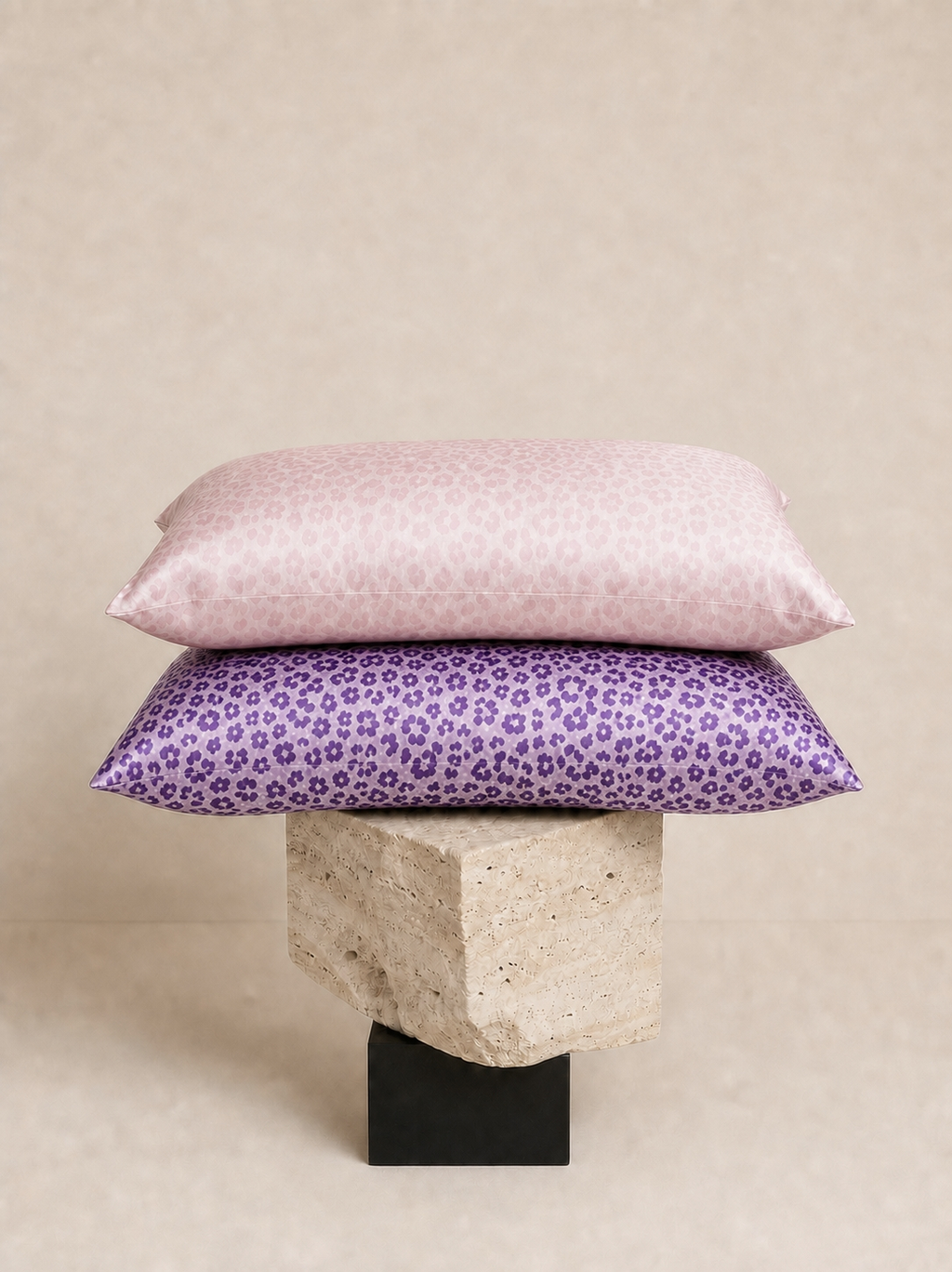 Pale Pink Leopard and Purple Leopard 22 momme silk front pillowcases stacked on a sculptural pedestal.