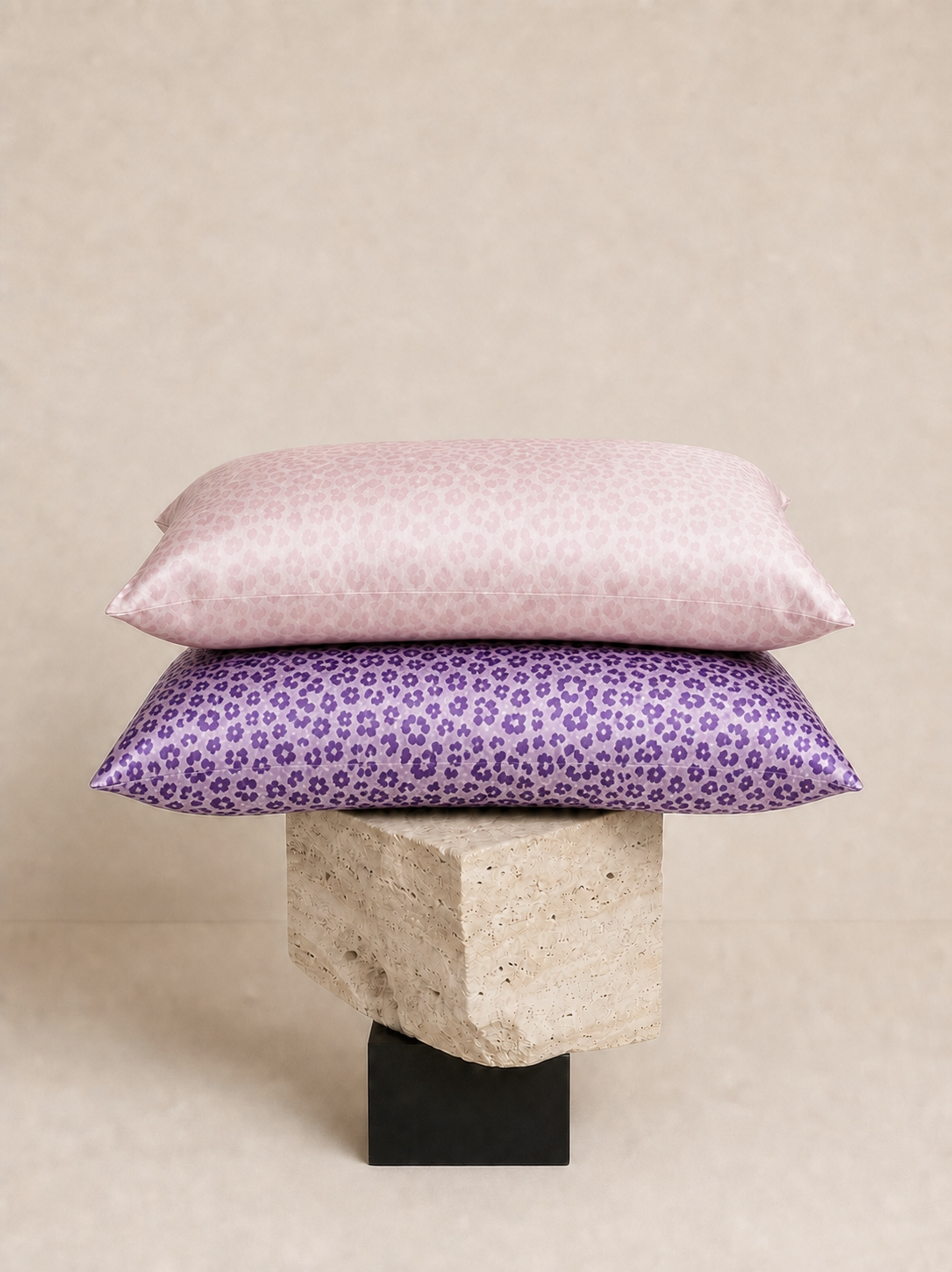 Pale Pink Leopard and Purple Leopard 22 momme silk front pillowcases stacked on a sculptural pedestal.