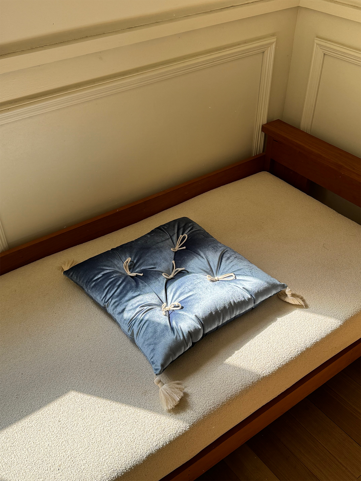 Celestial Velvet Léonie tufted tassel throw pillow displayed on a sunlit bench.