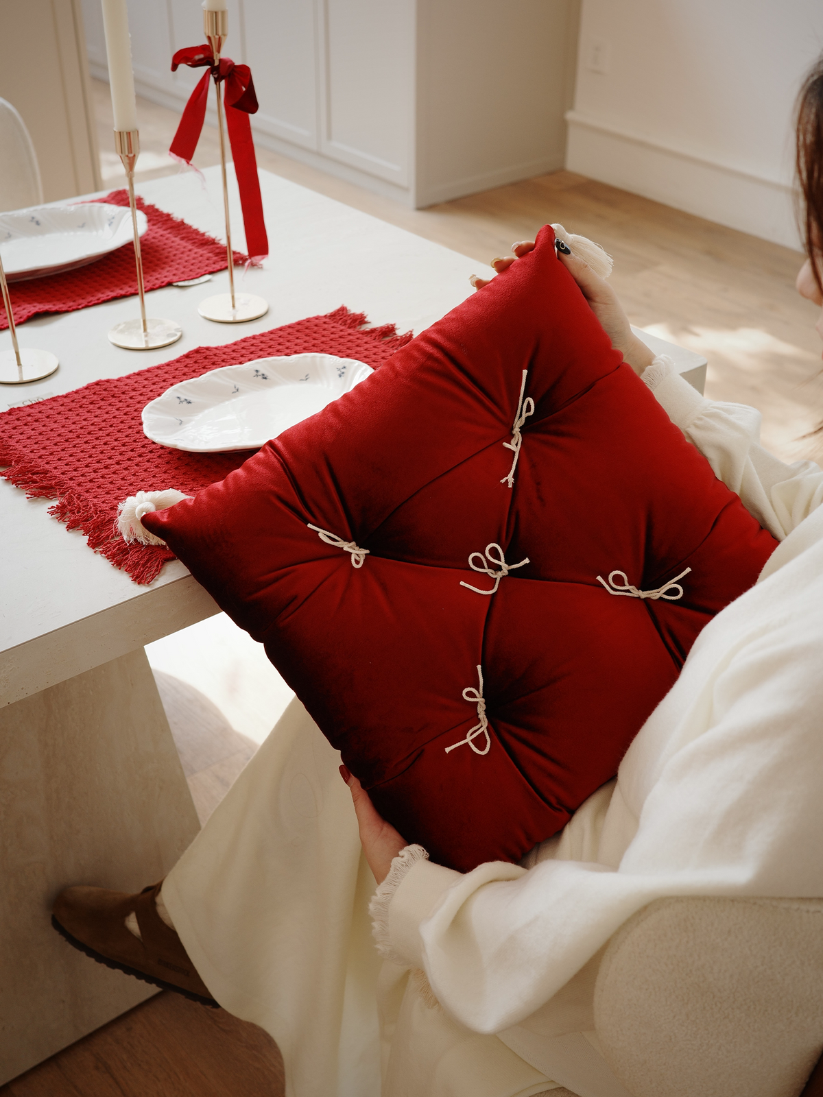 Rouge Velvet Léonie tufted tassel throw pillow styled in a dining room.