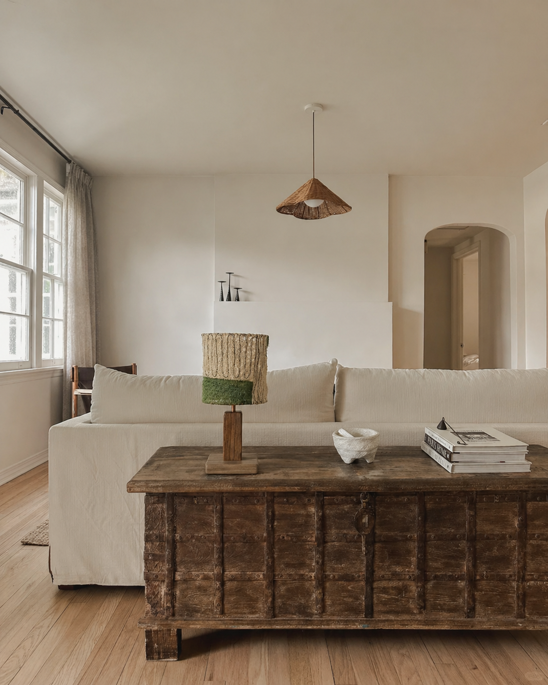 Wabi-Sabi Loofah & Aged Wood Table Lamp - Moss styled on a rustic wooden trunk in a bright living room showcasing the natural loofah shade with green moss accent